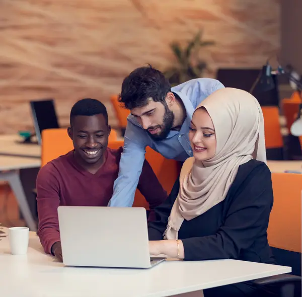 three people working together on a laptop